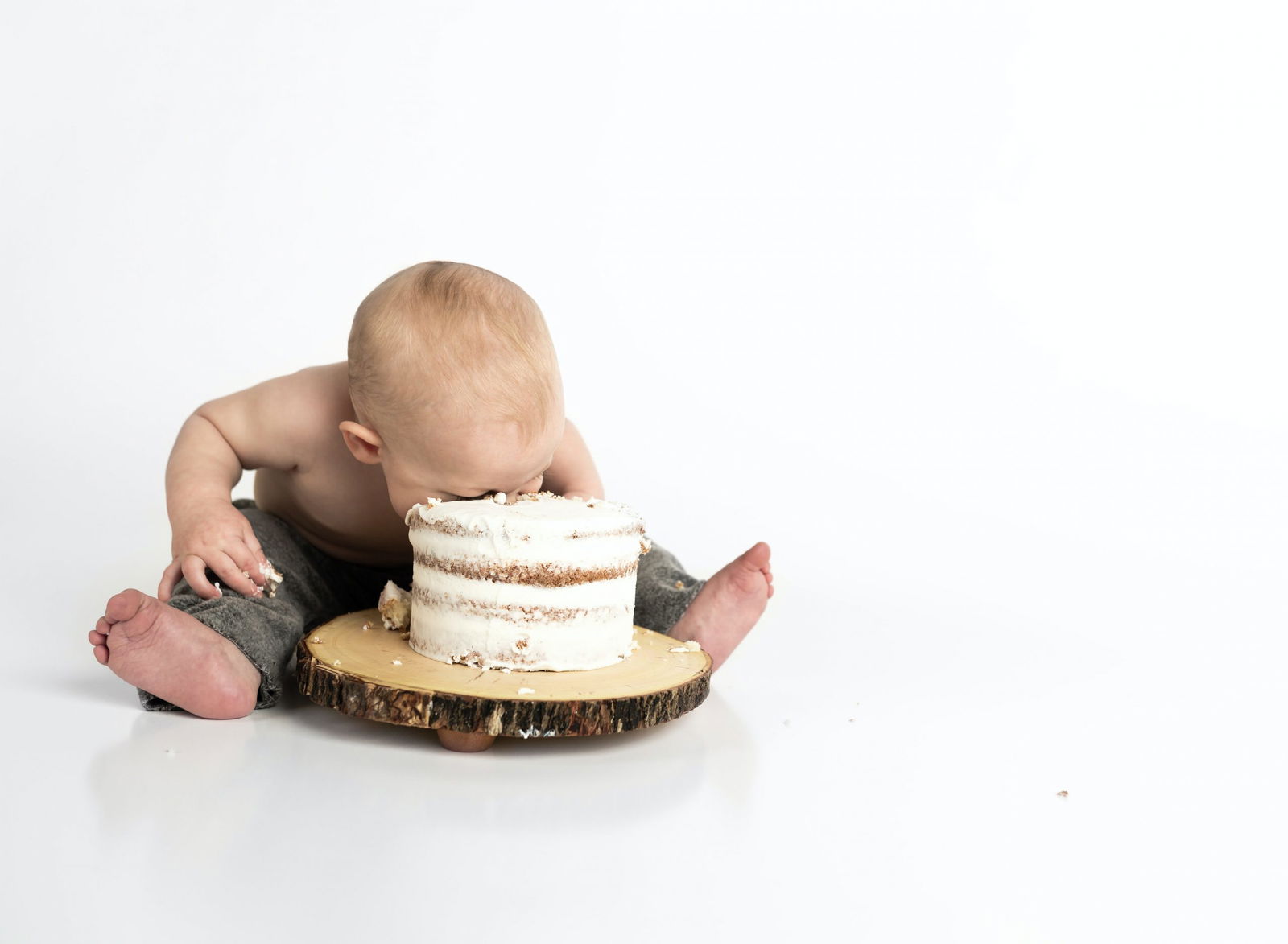 picture of a bay with his face in a cake