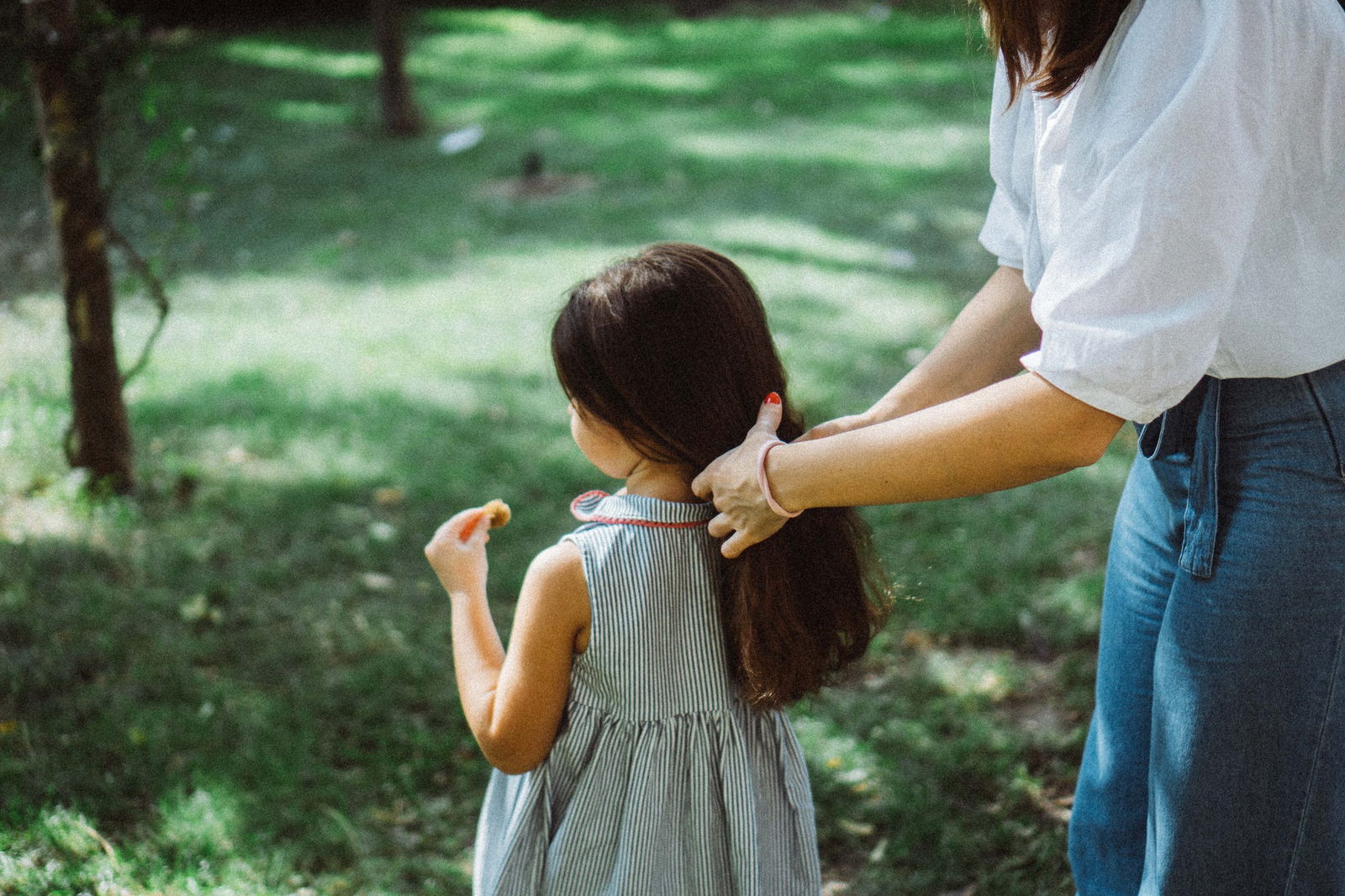 Image of mom putting a ponytail in daughter's hair