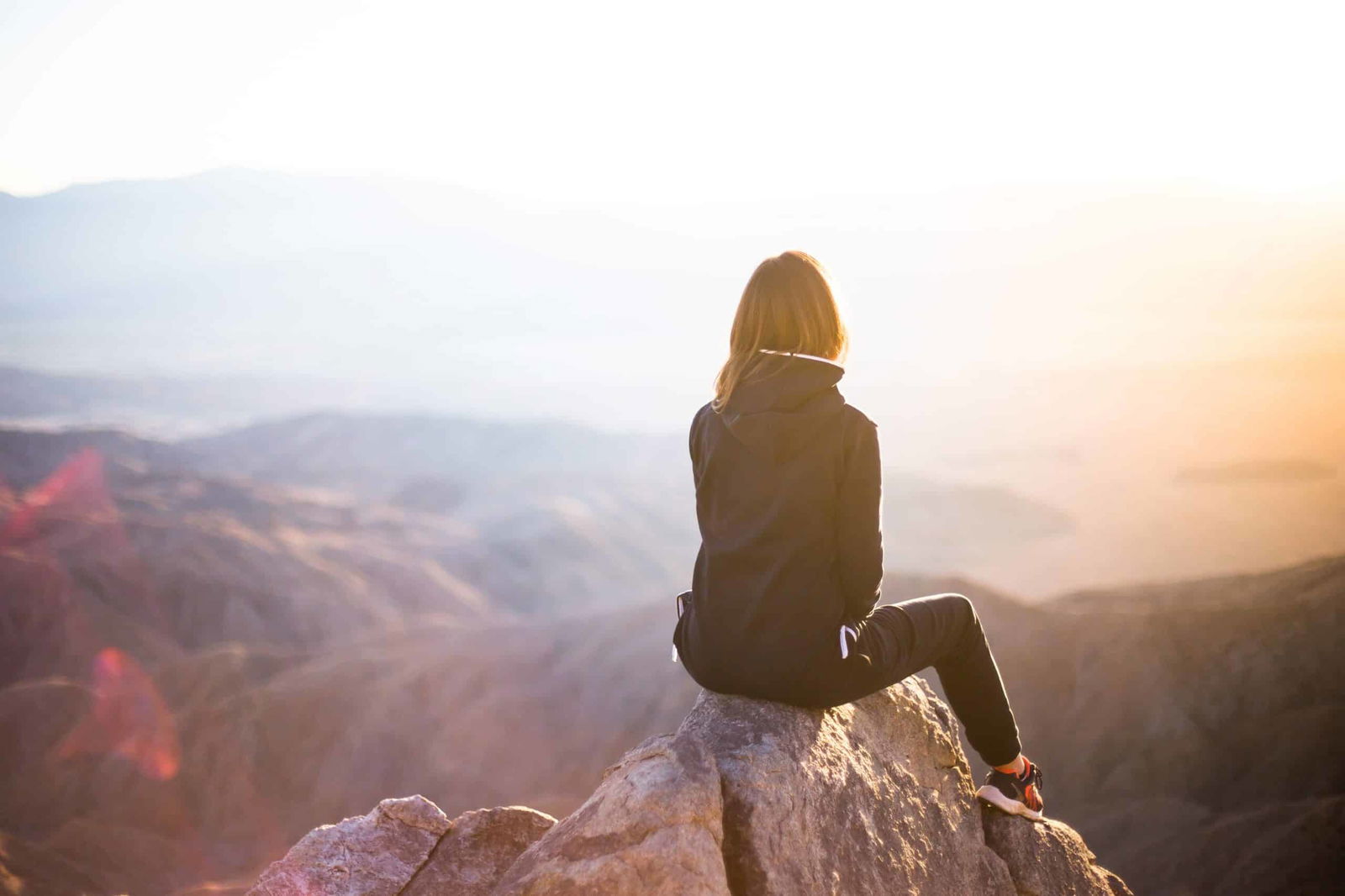 Woman sitting looking out at mountains