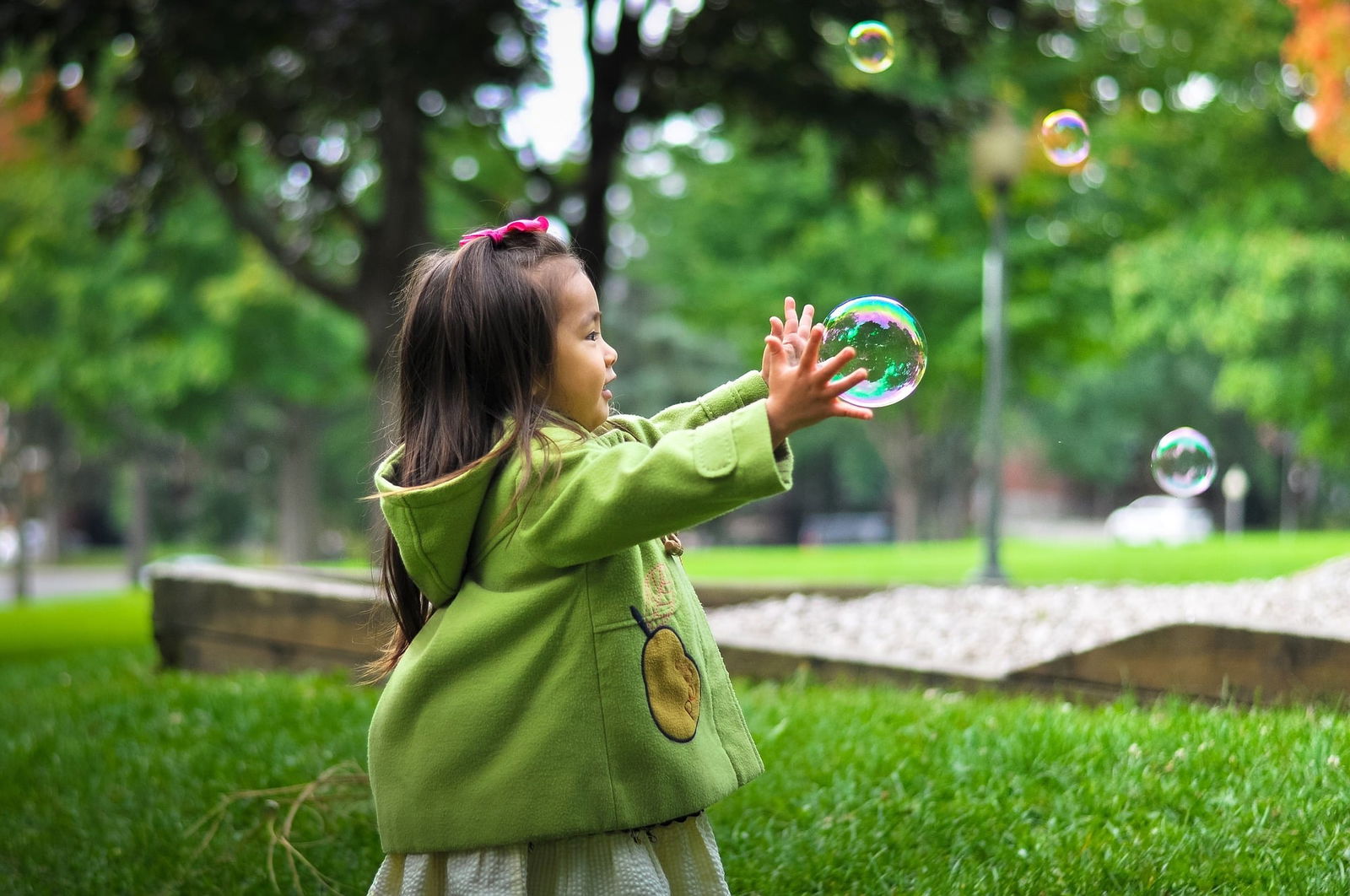 girl playing with bubble in field