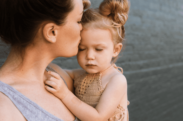 mom kissing her sad toddler