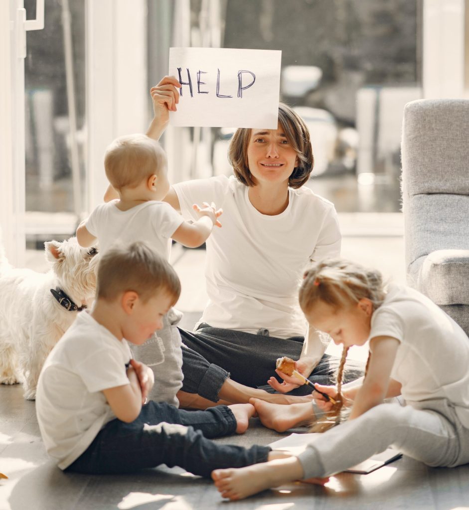 mom holding a sign that says help