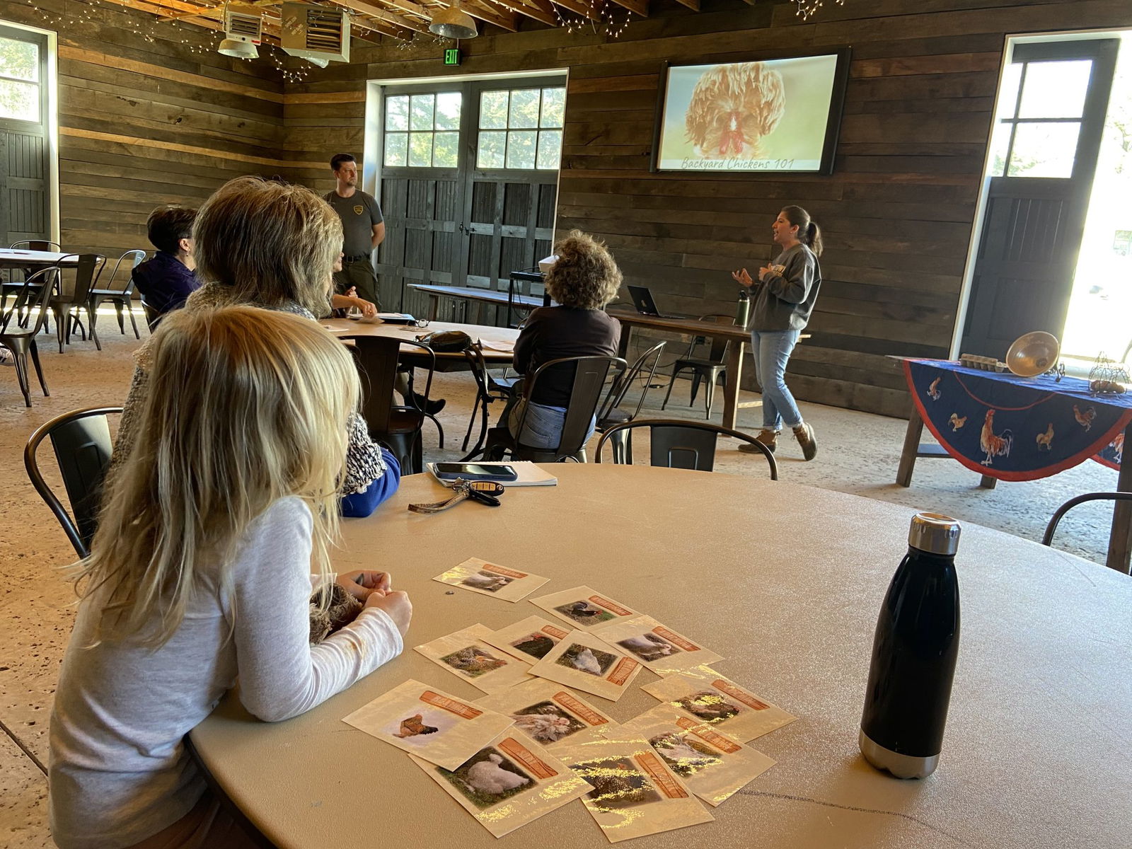 People sitting at tables listening to a presentation about chickens at Bobby Lanier Farm Park