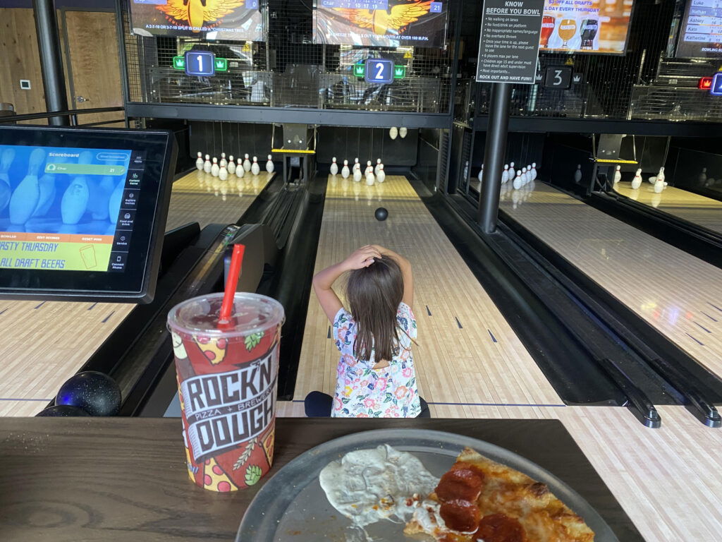 Child playing duckpin bowling at Rock n' Dough Orleans Station