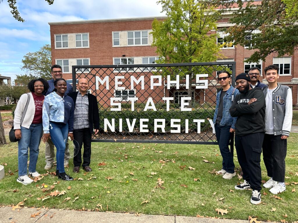 particiapnts in front of a Memphis State sign